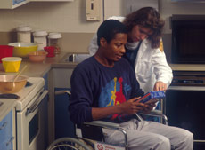A nurse helping a man who is in a wheelchair