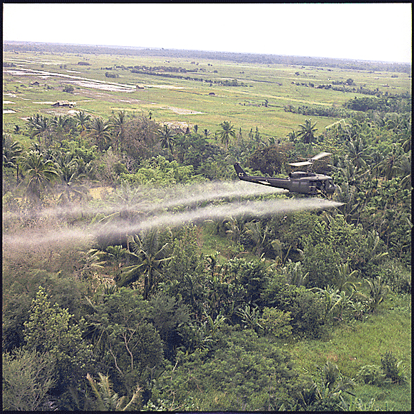 Helicopter spraying herbicide over jungle in Vietnam
