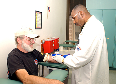 A veteran has his blood drawn by a doctor.