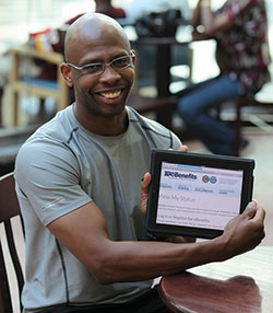 male veteran holding tablet showing eBenefits homepage