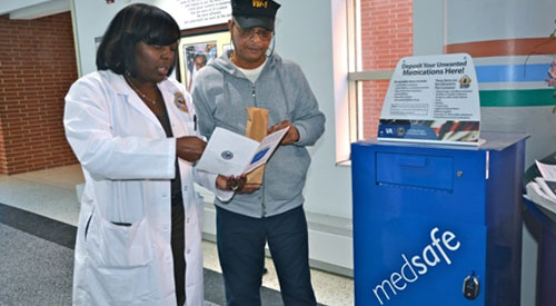 Help prevent drug misuse Doctor helping a veteran dispose of unused medication