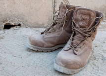 Dusty boots sitting on top of sand