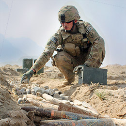 Soldier with munitions laid out to be destroyed