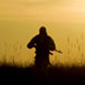 Silhouette of a soldier in front of the bright sun