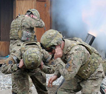 Servicemen are covering their ears to shield them from the noise of a blast