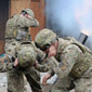 Servicemen are covering their ears to shield them   from the noise of a blast