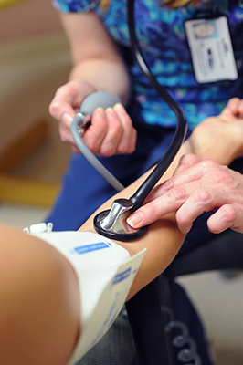 Nurse taking a patients blood pressure.