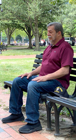 Mature man meditating on a park bench.