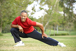 man stretches in a park