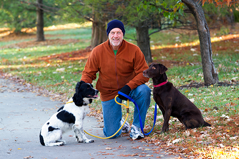 Man kneeling with his 2 pet dogs