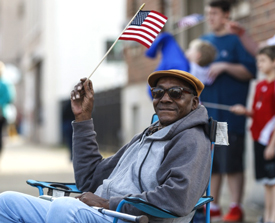 vietnam-era vet sitting outside with a small flag.
