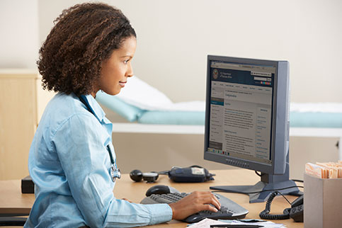 Doctor at a desk, on a computer