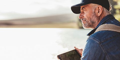 Man with a tablet, at a lake