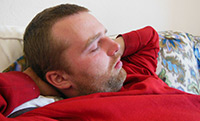 A napping man in a red sweater