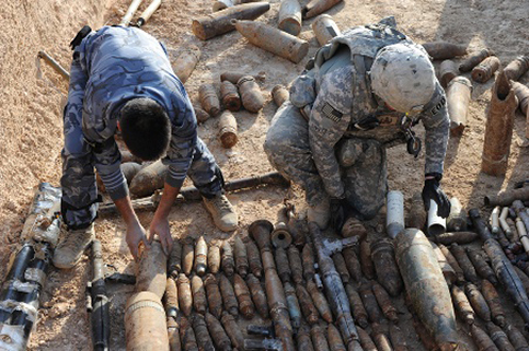 Soldiers arrange munitions on the ground