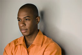 A close-up of a young man in orange shirt
