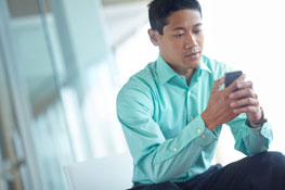A young male veteran texting a message to the smokefreeVET text line.